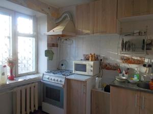 een keuken met een fornuis en een magnetron bij Peace avenue in Kiev