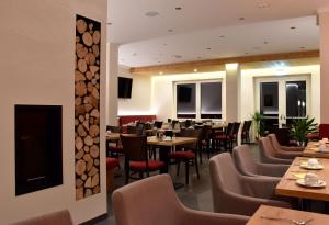 a restaurant with wooden tables and chairs and tables and chairs at Ferienhotel Wolfsmühle in Rodishain