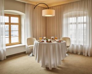 ein Esszimmer mit einem Tisch mit weißer Tischdecke in der Unterkunft Hotel Bulwar in Toruń