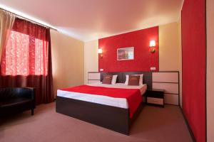 a bedroom with a bed and a red wall at Aliva in Ryazan