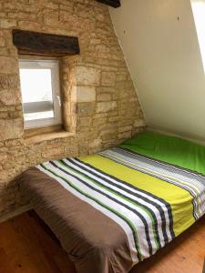 Bett in einem Zimmer mit einer Steinmauer in der Unterkunft Gîte Chez Zoa in Gignac
