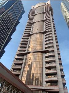 a tall building with the sun shining on it at Hostel Dubai in Dubai