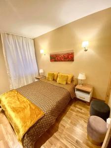 a bedroom with a bed with yellow sheets and a window at Vaļņu Ielas Apartments in Cēsis