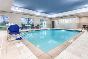 a swimming pool with a chair and a recliner in a hotel at Holiday Inn Express & Suites Hammond, an IHG Hotel in Hammond