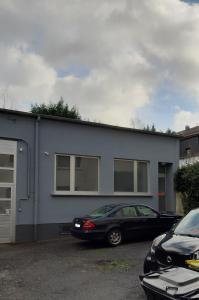 ヴッパータールにあるModern und Ruhig in Wuppertal mit Heimkino-Beamer! Top Ausstattung und Privatparkplatz an der Unterkunftの建物の前に車が駐車されている