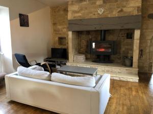 ein Wohnzimmer mit einer weißen Couch und einem Kamin in der Unterkunft Gîte Chez Zoa in Gignac