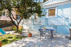 a table and chairs in front of a blue house at The Swallow's Seaview Nest by Konnect in Ágios Márkos