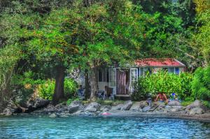 een huis aan de oever van een rivier bij International Glamping Lago Di Bracciano in Trevignano Romano