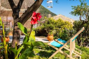 una silla y una flor en un patio en The Swallow's Seaview Nest by Konnect, en Ágios Márkos