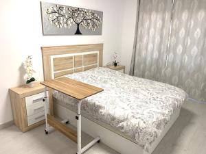 een slaapkamer met een bed en een houten tafel bij Casa Sergio de Novelda in Novelda