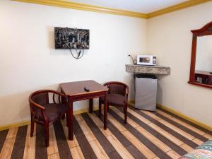 a room with a table and two chairs and a microwave at Parkside Inn in Long Beach