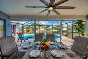 een eetkamer met een tafel en stoelen en een plafondventilator bij Villa Sunset Cape Coral in Cape Coral
