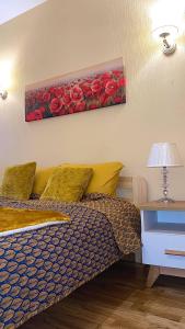 1 dormitorio con 1 cama y una pintura de rosas rojas en Vaļņu Ielas Apartments, en Cēsis