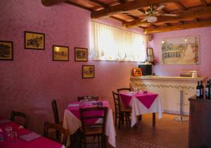 マンチャーノにあるAgriturismomillefioriのピンクの壁のダイニングルーム(テーブル2台付)