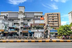 艾哈迈达巴德Hotel Palliate的一座高大的建筑,前面停有摩托车