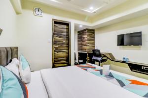 a bedroom with a bed and a desk and a tv at Hotel Palliate Ellisbridge in Ahmedabad