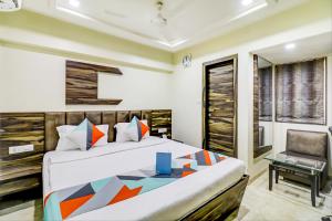 a bedroom with a king sized bed and a chair at Hotel Palliate Ellisbridge in Ahmedabad