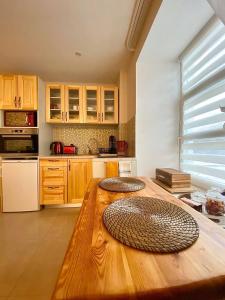 una cocina con una mesa de madera con dos platos. en Vaļņu Ielas Apartments, en Cēsis