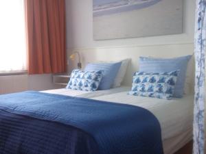 a bed with two pillows on top of it at Hotel Hoogland Zandvoort aan Zee in Zandvoort
