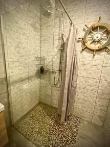 a shower with a glass door in a bathroom at Vaļņu Ielas Apartments in Cēsis