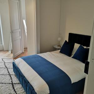 Un dormitorio con una cama azul y blanca y una puerta en Suite Mermoz -T3- Belle vue - Billard-wifi-Vélo en Castelnaudary