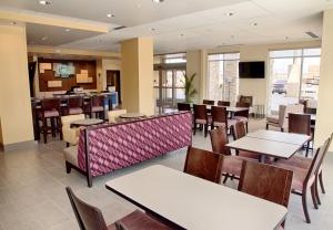 a restaurant with tables and chairs and a bar at Holiday Inn Express and Suites Tahlequah, an IHG Hotel in Tahlequah