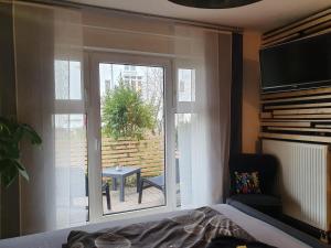 a bedroom with a window with a view of a patio at Black & Wood Design FeWo im Zentrum in Cottbus