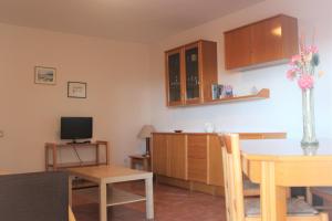 a living room with a table and a tv at Apartaments Lamoga - Monteixo in Torredembarra