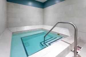 a swimming pool in a room with a tile wall at Holiday Inn Express Hotel & Suites Minneapolis-Downtown Convention Center, an IHG Hotel in Minneapolis