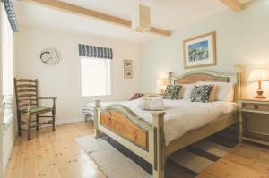 a bedroom with a bed and a chair and a window at Vinegar Hill Pottery in Lymington