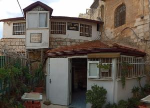 Cette maison ancienne dispose d'une porte blanche et d'une fenêtre. dans l'établissement Jaffa Gate Hostel, à Jérusalem