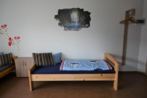 a bed sitting in a room with a wall at Pension NELE für Monteure NAHE Berlin in Mittenwalde