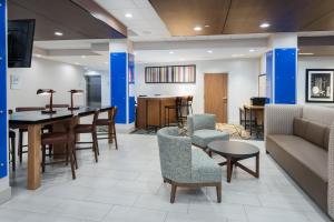 een lobby met een bank, stoelen en een tafel bij Holiday Inn Express & Suites- Sugar Land SE - Missouri City, an IHG Hotel in Missouri City