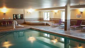 Holiday Inn Express Hotel & Suites Wichita Northeast, an IHG Hotel في ويتشيتا: مسبح كبير مع حوض استحمام ساخن في مبنى