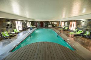 a large swimming pool in a building with green chairs at Holiday Inn Express Hotel & Suites Clinton, an IHG Hotel in Clinton