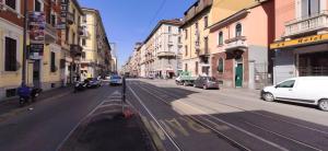 an empty city street with cars parked on the road at Grand Hostel Coconut in Milan