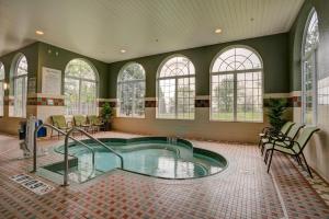 a large indoor pool in a room with windows at Holiday Inn Milwaukee Airport by IHG in Milwaukee