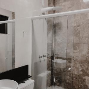 ein Bad mit einer Dusche, einem WC und einem Waschbecken in der Unterkunft Petri Plaza Hotel in Francisco Beltrão
