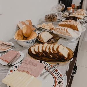 a table filled with different types of bread and pastries at Petri Plaza Hotel in Francisco Beltrão