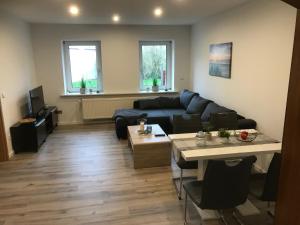 a living room with a couch and a table at Ferienwohnung Weserbergland Haus Nr 29 Erdgeschoss in Deensen