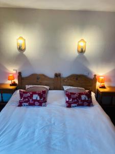 um quarto com uma cama com almofadas vermelhas e 2 candeeiros em L'Auberge au Bord du Lac em Gérardmer