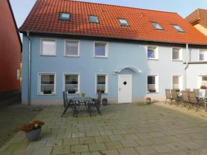 a blue and white house with chairs and a table at Mecklenburger Hof in Mirow