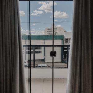 una ventana con vistas a un edificio y cortinas en Petri Plaza Hotel en Francisco Beltrão
