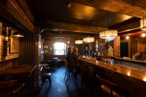 two people sitting at a bar in a restaurant at Rooms at the Lower House in Dungannon