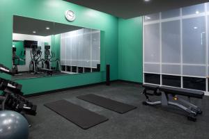 a gym with a green wall and a mirror at Holiday Inn & Suites Orlando - International Dr S, an IHG Hotel in Orlando