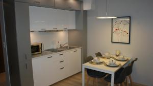 een keuken met een tafel met stoelen en een magnetron bij Apartament Agata in Świnoujście