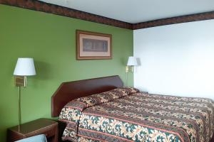 a bedroom with a bed and a green wall at OYO Hotel Kings at Clovis in Clovis