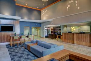 a lobby with a blue couch and a bar at Holiday Inn Milwaukee Airport, an IHG Hotel in Milwaukee