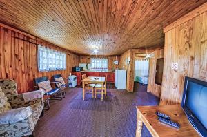 a living room with a television and a dining room at Amper Bo Guest House in Pretoria