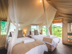 A bed or beds in a room at Shindzela Tented Camp